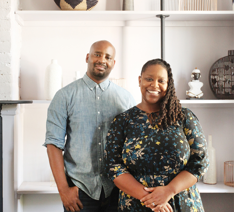 AphroChic designers Jeanine Hays and Bryan Mason stand together in front of bookcase