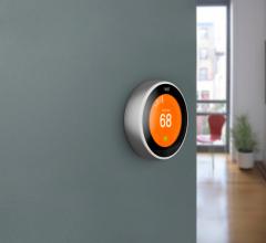 Nest smart home thermostat on green wall