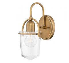 The Clancy wall sconce from Hinkley Lighting measures just 6 by 11.3 inche. Made of steel and clear glass, ideal for an Edison bulb. Available in five finishes, shown here in Heritage Brass. with Heritage brass backplate and arm and clear glass surrounding the bulb from Hinkley Lighting