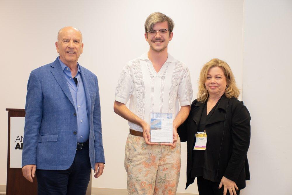 Scott Grove, center, accepts the 2024 Richard Frinier Design Scholarship from Richard and Cathy Frinier.